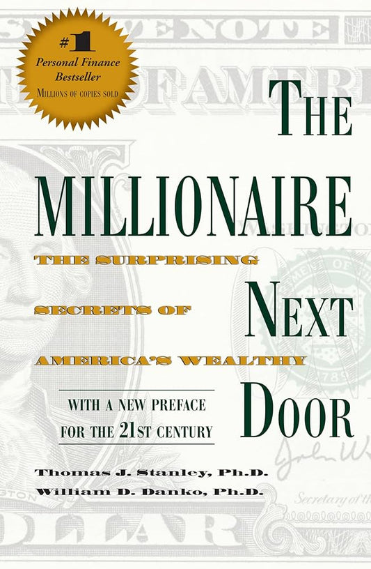  "The Millionaire Next Door" by Thomas J. Stanley and William D. Danko. The cover features a background that resembles a hundred-dollar bill, giving it a financial theme. The title "THE MILLIONAIRE NEXT DOOR" is prominently displayed in large, dark green letters. Below the title, in smaller orange text, it reads "THE SURPRISING SECRETS OF AMERICA'S WEALTHY." At the bottom, the authors' names, "Thomas J. Stanley, Ph.D. and William D. Danko, Ph.D.," are printed in black text. A gold starburst in the top left 